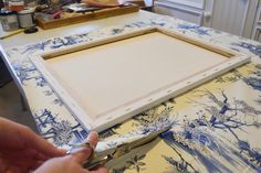 a person is using scissors to cut up a piece of fabric on top of a table