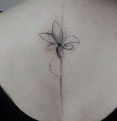 a woman's back with a flower tattoo on it