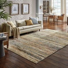 a living room filled with furniture and a large rug on top of a hard wood floor