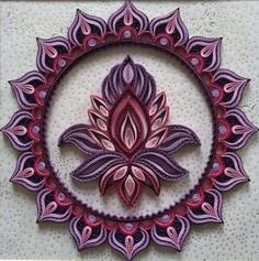 an intricate purple and red design on a white wall