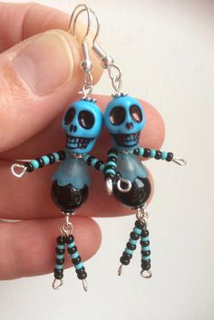 a pair of blue and black beaded skeleton earrings