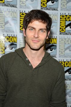 a man standing in front of a panel of comic books