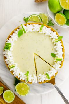 there is a pie with limes around it on the table