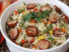 a white bowl filled with rice and sausage