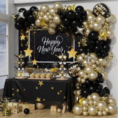 a new year's eve party with black and gold balloons, stars, and decorations