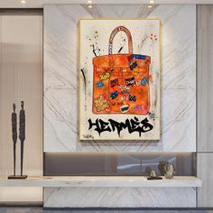 an orange handbag is hanging on the wall above a white counter in a lobby