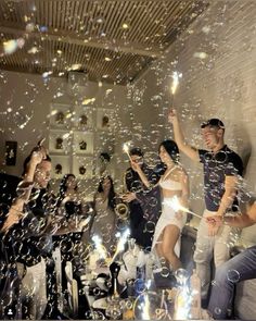 a group of people that are standing in the air with soap bubbles floating around them