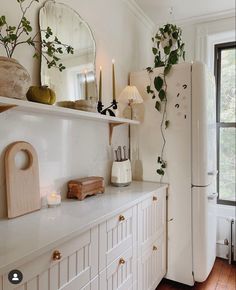 a white refrigerator freezer sitting inside of a kitchen next to a wall mounted clock