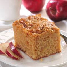 a piece of cake sitting on top of a white plate next to an apple slice