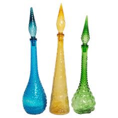 three different colored glass vases sitting side by side