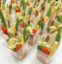 several small trays filled with different types of food on top of a white table