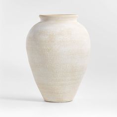 a white vase sitting on top of a table