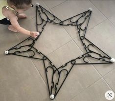 a child playing with a star shaped object on the floor