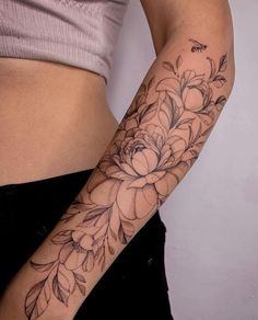 a woman's arm with flowers and leaves tattooed on the left side of her body