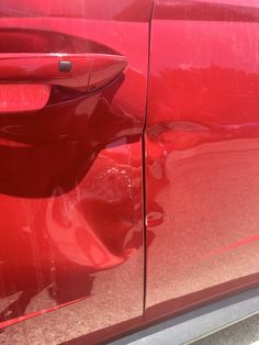 the side door of a red car that has been scratched