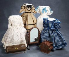 several dresses and suitcases are arranged on a gray background