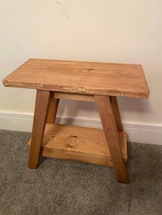 a small wooden table sitting against a wall