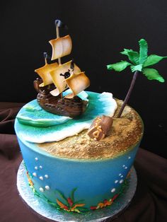 there is a cake with a pirate ship on it and a palm tree in the middle