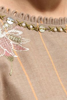 a close up of a woman's neck wearing a dress with flowers on it