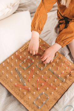 a child playing with an abacus board on a bed