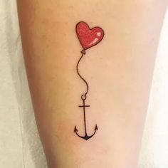 an anchor with a heart balloon attached to it's side tattoo on the leg