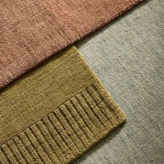 three different colored rugs on top of each other, one with a brown stripe