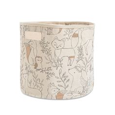 a small storage basket with animals and plants printed on it, sitting on a white background