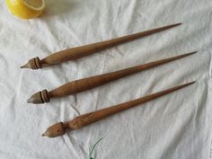 three old wooden spoons sitting on top of a white cloth next to an orange