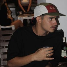 a man sitting at a table with a beer in his hand