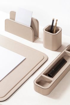 a desk set with pen, pencil and paper holder on it's side next to a laptop