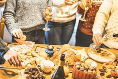 a group of people standing around a table filled with food