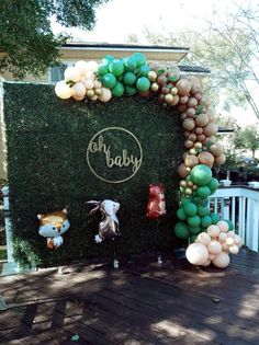 an outdoor display with balloons and teddy bears on the front door for baby's first birthday