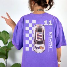 Denny Hamlin NASCAR shirt! 🏁👕 Rev up your wardrobe with our exclusive Denny Hamlin NASCAR t-shirt featuring your favorite driver's name, number, and car! Crafted with the finest materials, this shirt boasts durability and comfort, making it perfect for everyday wear or race-day excitement. Whether you're cheering trackside or from the comfort of your couch, this shirt is a must-have for any die-hard NASCAR fan. Show your support for your favorite driver in style and make a statement at every t Purple Short Sleeve Tops For Fan Merchandise, Denny Hamlin Nascar, Nascar Shirt, Denny Hamlin, Nascar Shirts, Nascar T Shirts, Nascar Driver, Nascar Racing, Die Hard