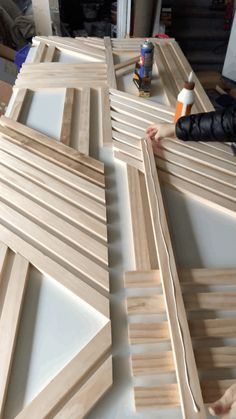 two people are working on some wood pieces in the process of being made into an art project