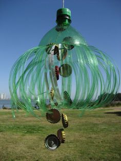 a wind chime hanging from the side of a grass covered field