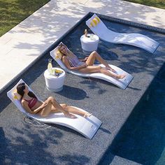 three women lounging on lounge chairs next to a swimming pool