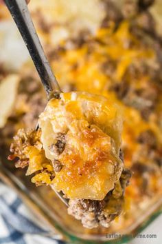 a spoon full of cheeseburger casserole with meat and potatoes