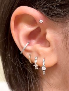 a close up of a person with ear piercings and an earring on their left side