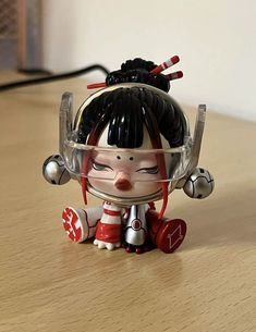 a small toy doll sitting on top of a wooden table