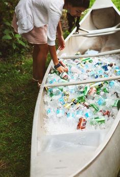 a boat filled with lots of bottles sitting on top of a lush green field