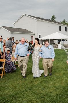 a bride and groom walking down the aisle at their outdoor wedding in front of a barn