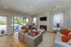 a living room filled with furniture and a flat screen tv mounted to the wall over a fireplace