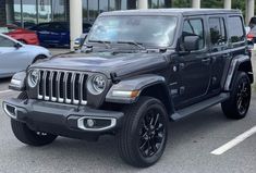 a black jeep is parked in a parking lot