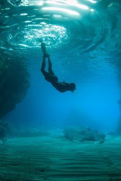 a person swimming in the water with their feet up and head above the water's surface