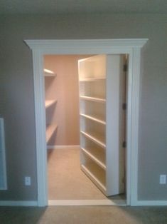 an empty closet is shown with shelves in the corner and door open to another room