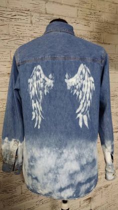 a denim jacket with angel wings painted on it