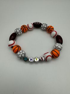 Show off your love for sports with our custom-made Sports Beads Bracelet! Perfert for athletes, sports enthusiasts, or anyone who loves to show team spirit. Each bracelet is handcrafted with high-quality beads representing your favorite sport(s). Whether you love baseball, football, soccer, or a mix of all three, we've got you covered! Customizable White Sports Bracelets, White Casual Wristband For Sports, Casual White Wristband For Sports, White Team Spirit Bracelets For Game Day, White Team Spirit Wristband For Sports, Sporty Personalized Bracelets For Sports Events, Personalized Sporty Wristband For Sports Events, White Team Spirit Wristband For Sports Events, Sporty Letter Beads Wristband For Sports Events