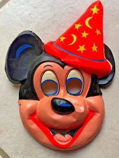 a mickey mouse mask with a red hat and stars on it's head is shown