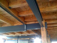 the inside of a building with wood and metal beams