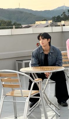 a man sitting at a table on top of a roof